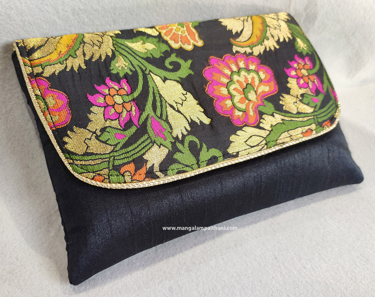 A clutch purse with a floral design and a detachable chain strap in gold color.