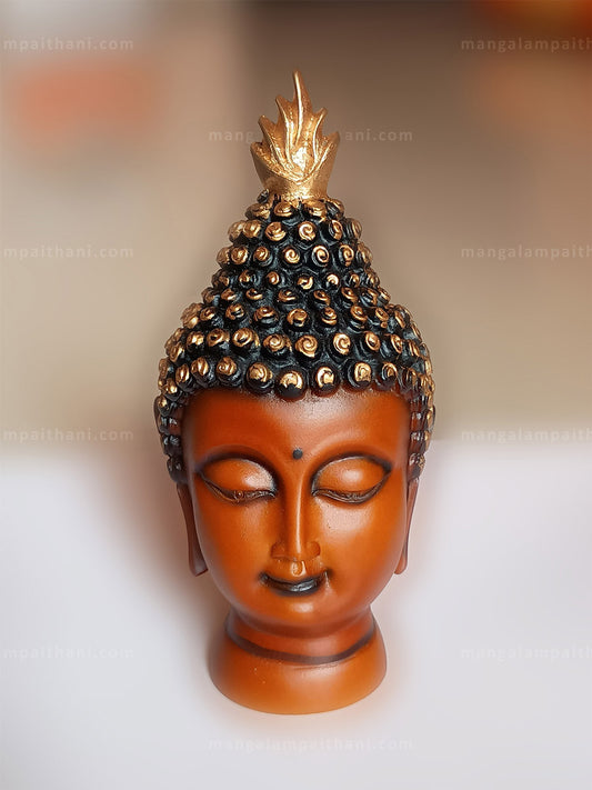 Buddha head sculpture with a golden crown
