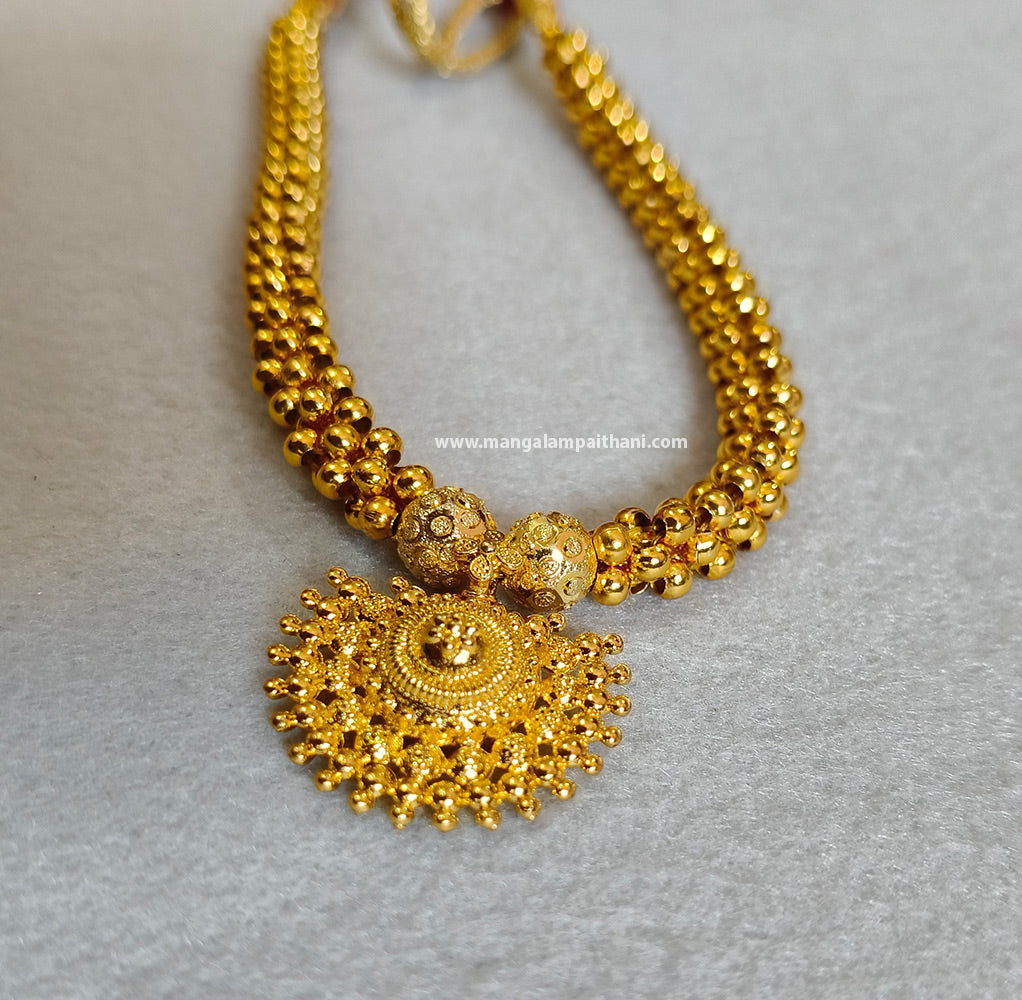 Gold plated choker necklace with a floral design on the pendant.