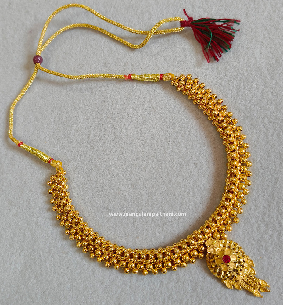Gold plated choker necklace with a red and yellow design and a tassel at the end