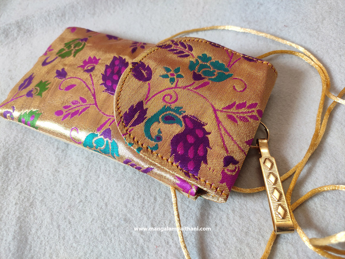 A multicolored floral Paithani mobile pouch with a zipper